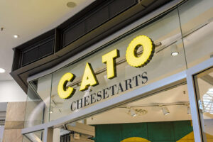 Detailaufnahme vom Firmenschild vom Cato Cheesetarts Store im Westfield Centro Oberhausen